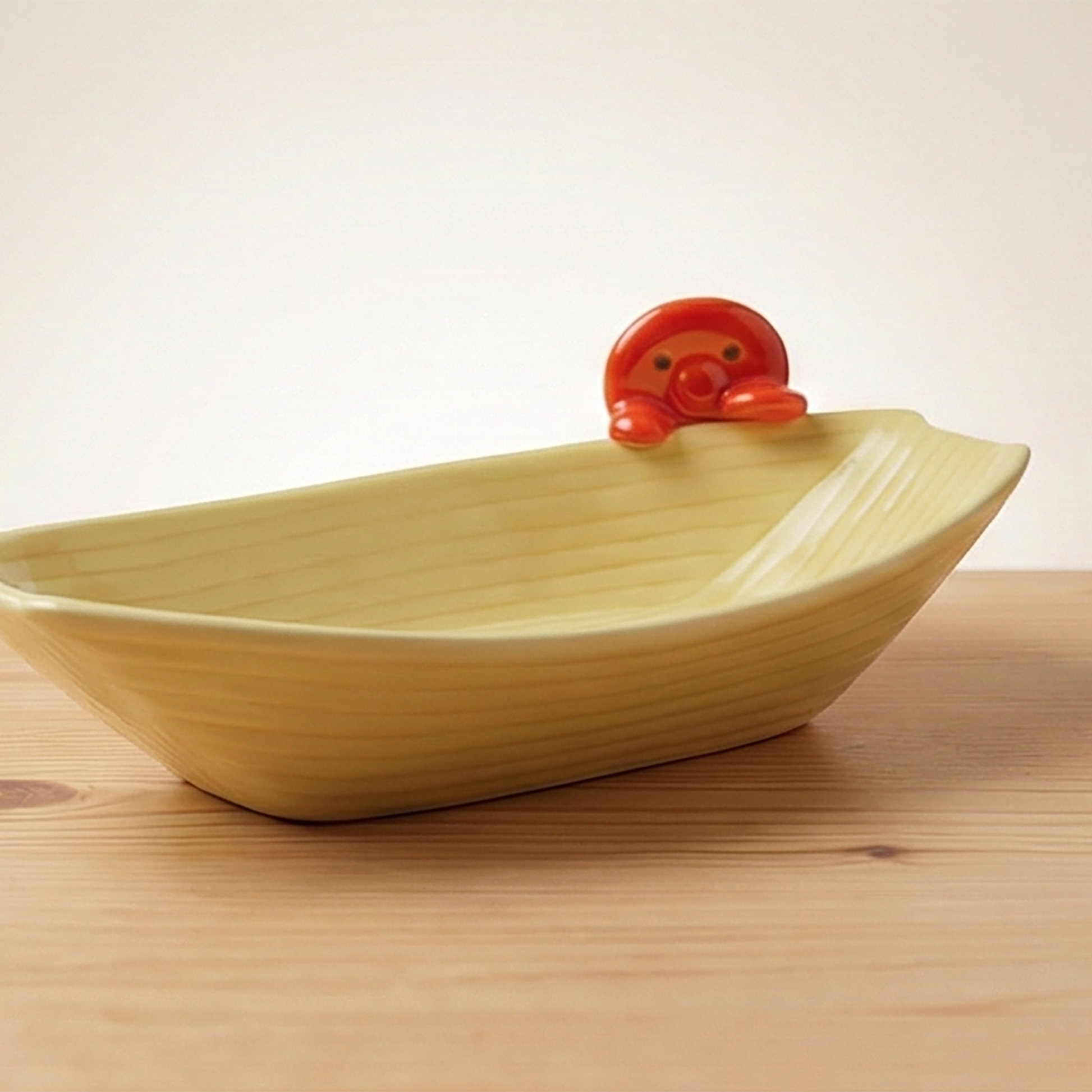 Cremefarbene längliche Schiffchen-Schale mit rotem Takoyaki-Octopus Griff oben