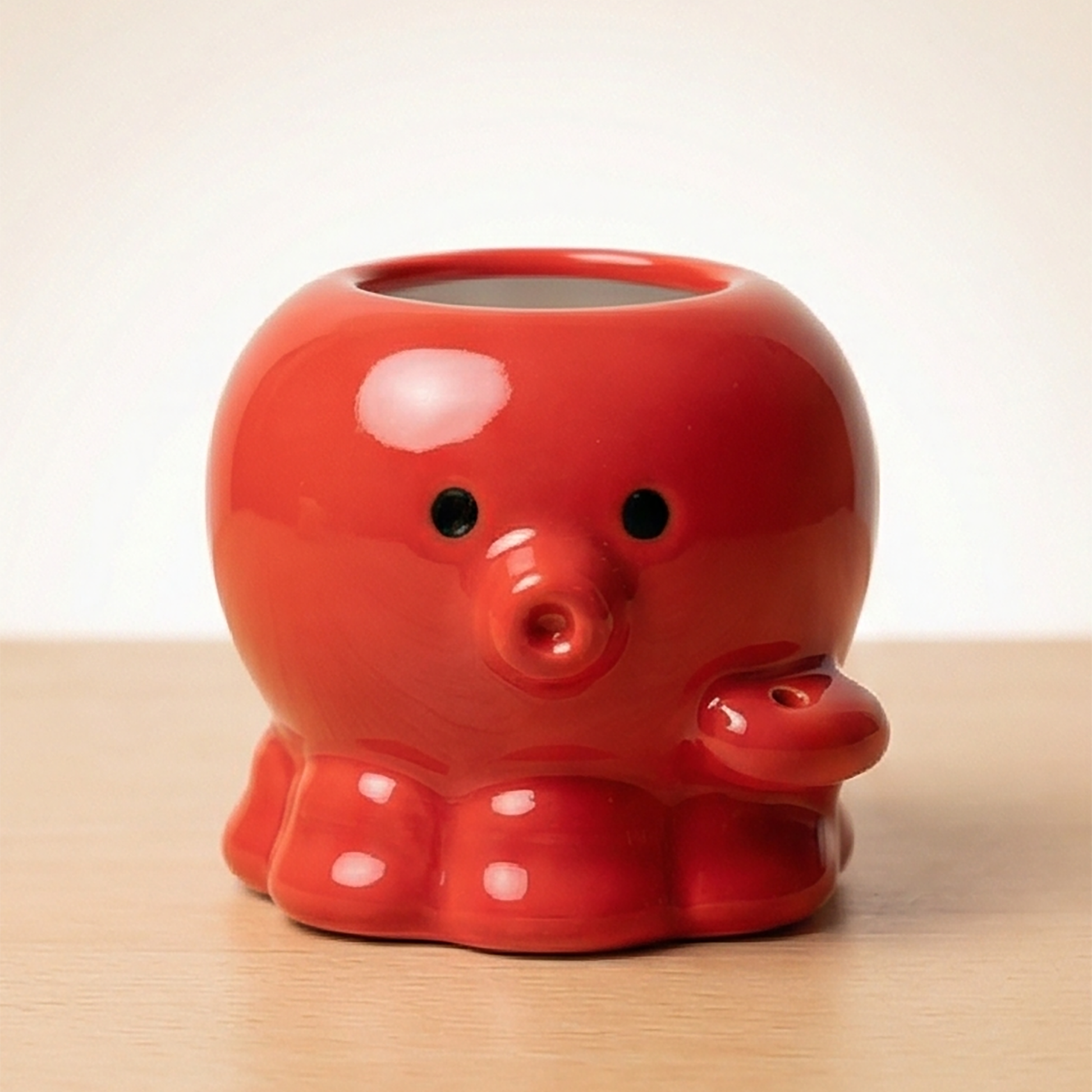 Roter keramischer Takoyaki-Oktopus Zahnstocherhalter von vorne mit großen schwarzen Augen und rundem rotem Mund