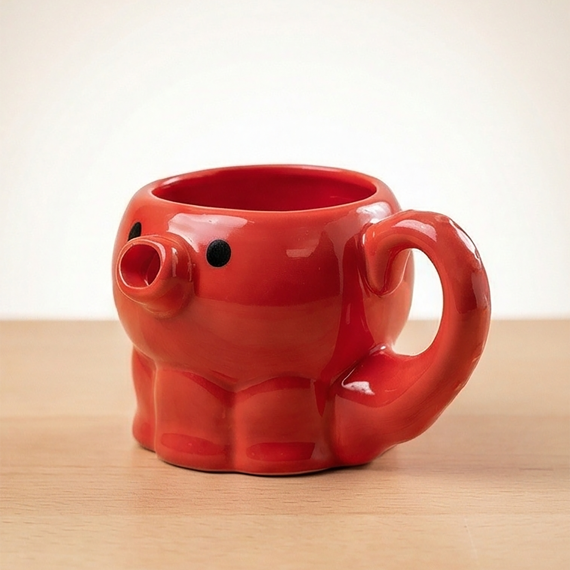 Rotes Takoyaki-Oktopus Teigkännchen mit Tentakel-Henkel und rundem Körper auf Holzuntergrund