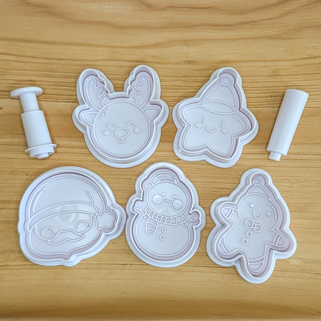 Weihnachts-Ausstechformen Set SNOWCHAN – Plätzchenformen für festliche Motive. | Verschiedene weiße Ausstechformen auf Holzuntergrund.