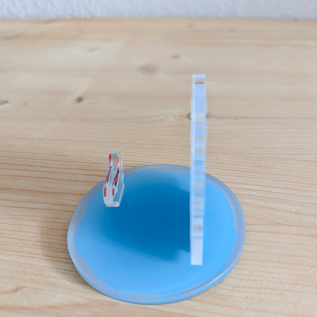 Seitenansicht des Smartphone-Ständers mit Smartphone in vertikaler Position und rundem blauem Sockel