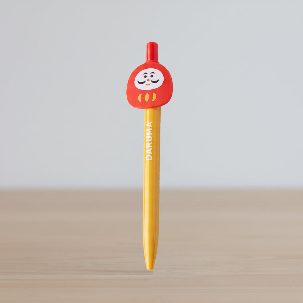 Daruma Kugelschreiber mit roter Glücksbringer-Puppe auf Kappe und gelbem Schaft