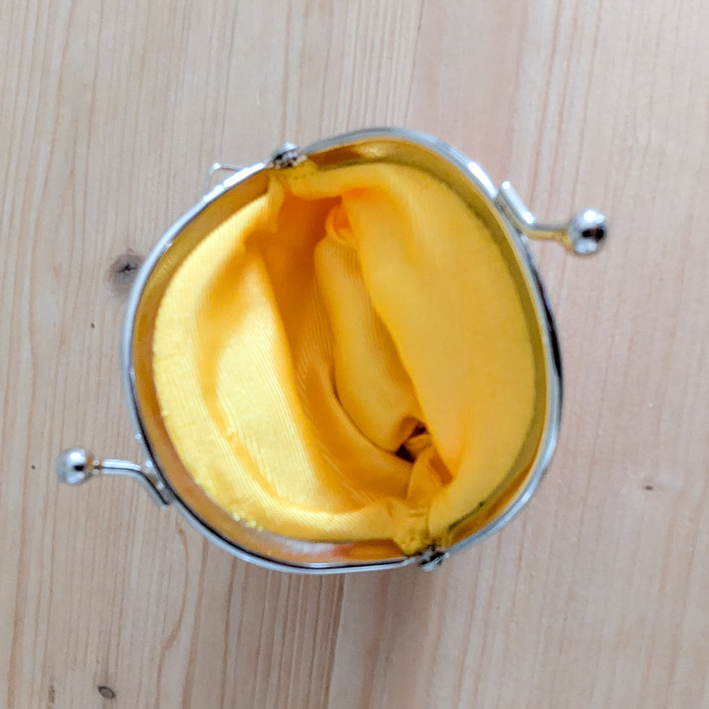 Innenseite der Stoff-Geldbörse Manekineko mit gelbem Futter und Metallrahmen von oben