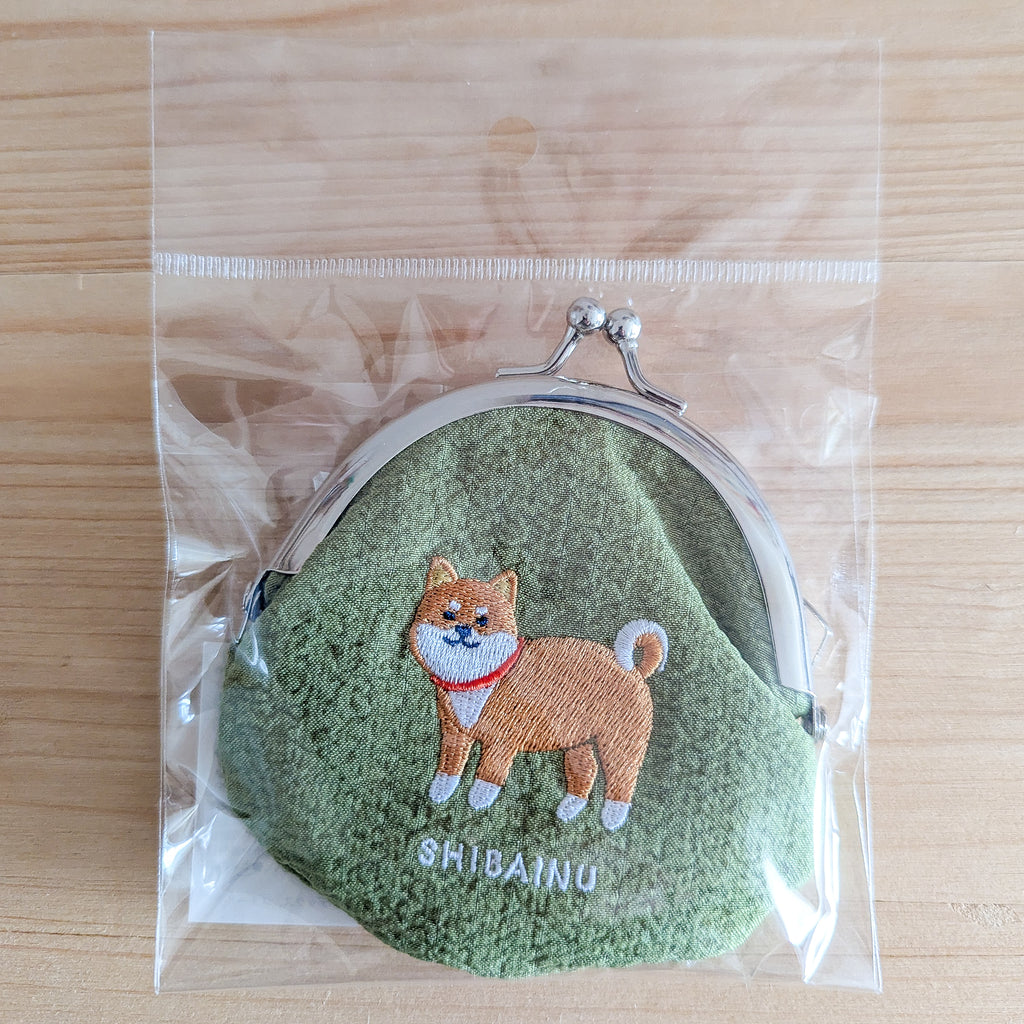 Stoff-Geldbörse Shiba Inu in Plastikverpackung auf Holzoberfläche mit Maßstab