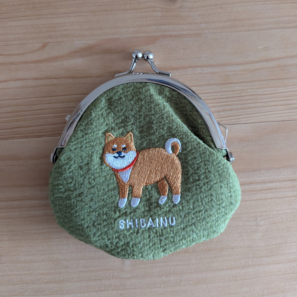 Grüne Stoff-Geldbörse Shiba Inu mit Metallverschluss, Draufsicht auf Holztisch